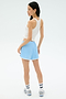 A woman faces away against a light background, wearing the Splits59 Ashby Rib Tank in white, paired with light blue athletic shorts, striped socks, and sneakers.