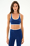 A woman with long brown hair models the SPLITS59 Hayley Active Rib Bra - Heather Cobalt/White and matching high-waisted leggings against a plain white background.