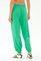 Model wears the SPLITS59 Andie Oversized Fleece Sweatpant in Spearmint, shown from the back with white sneakers accented by green stripes, against a plain white background.