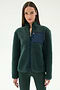 A woman wears the SPLITS59 Harris Sherpa Jacket in Military/Indigo, featuring a navy chest pocket, while standing against a plain light background.