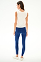 A woman wears the SPLITS59 Nikki Jersey Tank - White with blue textured spandex leggings and white sneakers, standing against a plain white background.