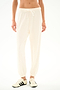 A person models the SPLITS59 Andie Oversized Fleece Sweatpant - Creme, styled with white sneakers against a plain backdrop, ideal for cool weather comfort.