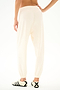 Person wearing SPLITS59 Andie Oversized Fleece Sweatpant - Creme and black-and-white sneakers, ideal for cool weather workouts, standing with back to camera on white background.