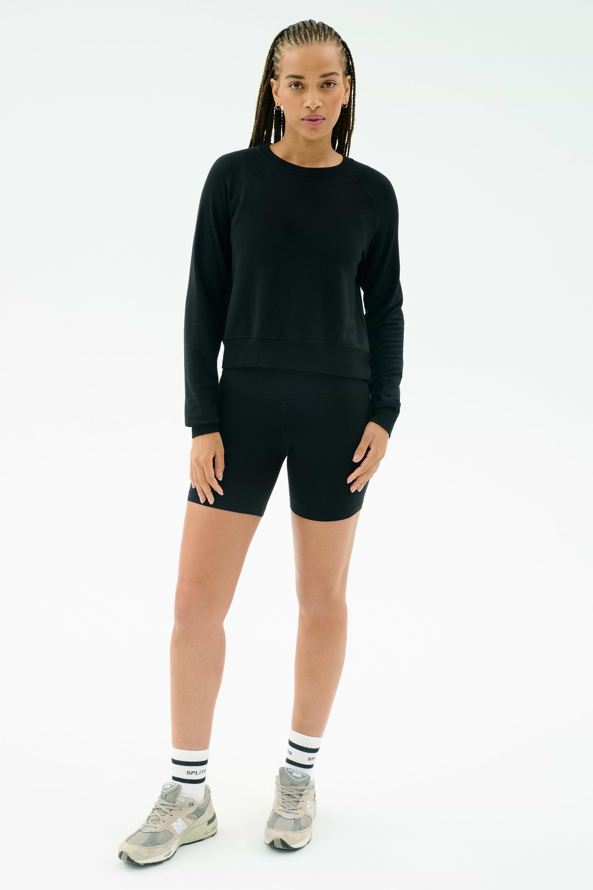 A person faces forward against a plain white background, wearing the SPLITS59 Brooks Fleece Long Sleeve Sweatshirt in black. This premium crewneck pullover is quality made in Los Angeles.