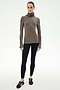 A woman stands facing forward against a plain white background wearing the SPLITS59 Jackson Rib Full Length Turtleneck in Lentil/Black, paired with black leggings and black sneakers.