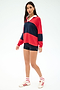 A woman stands against a white background wearing the SPLITS59 Katie Fleece Rugby in Pirate Red/Indigo, navy shorts, white socks with red stripes, and white Adidas sneakers with red accents.