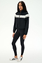 A person is wearing the SPLITS59 Morrison Nylon Twill Track Jacket in Black/Creme, paired with black spandex leggings and white sneakers, standing against a plain white background.