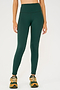 Front view of model wearing dark green high waist leggings and orange shoes