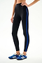 Model wearing SPLITS59 Clare High Waist Rigor 7/8 - Black/Cobalt leggings and blue Adidas sneakers, standing against a plain white background.