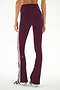 A person is shown from the back wearing the SPLITS59 Raquel High Waist Supplex Flare leggings in Dark Cherry/Crème, crafted from a comfortable spandex-nylon blend with two white side stripes. They are also wearing white sneakers with black stripes.