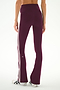 A person is shown from the back wearing the SPLITS59 Raquel High Waist Supplex Flare leggings in Dark Cherry/Crème, crafted from a comfortable spandex-nylon blend with two white side stripes. They are also wearing white sneakers with black stripes.