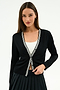 A woman models the SPLITS59 Bekah Knit Cardigan in Black/White—a soft rayon-nylon blend with white striped trim—over a white top and black pleated skirt, standing against a plain white background.