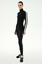 A person wearing the SPLITS59 Jackson Rib Full Length Turtleneck in Black/Creme, which features a white stripe on the sleeve, paired with black leggings and black athletic shoes, standing against a white background.