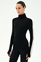 A woman wears the SPLITS59 Jackson Rib Full Length Turtleneck in Black/Creme, featuring a white stripe down the sleeve, as she stands against a plain light background.