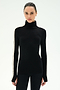 Wearing the SPLITS59 Jackson Rib Full Length Turtleneck in Black/Creme—a black sweater featuring creme stripes along the sleeves—a person stands facing forward against a plain white background.