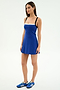 A woman stands against a plain background wearing the SPLITS59 Monah Rigor Dress in Cobalt/Black, paired with blue sneakers.