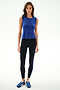 Woman standing against a white background, wearing the SPLITS59 Nikki Jersey Tank - Cobalt, black leggings with a blue stripe, and blue athletic shoes.