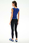 Woman facing away, wearing the SPLITS59 Nikki Jersey Tank - Cobalt, black leggings with blue accents, and blue athletic shoes against a plain light background.