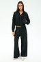 A woman stands facing forward wearing the SPLITS59 Peaches Airweight Cargo Jacket in black with black wide-leg stretch pants and white sneakers, set against a plain white background.