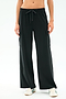 A person wearing SPLITS59’s Alex Airweight Cargo Pant in black, featuring side pockets and soft Airweight fabric, paired with white sneakers and standing against a plain light background.