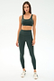 A woman faces forward wearing the SPLITS59 Airweight Rib High Waist 7/8 leggings in Military, paired with a matching sports bra and white sneakers against a plain white background.