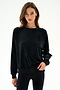 Woman wearing the SPLITS59 Joy Velour Crewneck - Black with black polyester spandex leggings, standing against a plain white background.