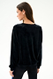 A woman with long brown hair wears the SPLITS59 Joy Velour Crewneck - Black and black polyester spandex leggings, standing against a plain white background, facing away.