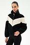A person wearing the SPLITS59 Lottie Chevron Sherpa Full Zip Jacket in Black/Creme, featuring a chevron pattern and crafted from 100% polyester, stands against a plain light background.