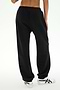 A person is shown from the waist down and viewed from the back, wearing SPLITS59 Serena French Terry Oversized Sweatpant in Black/59 with white sneakers, standing against a plain light background.
