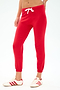 Wearing the SPLITS59 Sonja Fleece Sweatpant in Pirate Red, paired with white sneakers with red stripes, this look captures effortless Los Angeles style against a plain background.