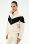 A person is wearing the SPLITS59 Lottie Chevron Sherpa Full Zip Jacket in Creme/Black, crafted from soft 100% polyester fleece with a black chevron stripe across the chest, paired with cream leggings featuring a black side stripe, standing against a plain white background.