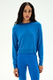 A woman wears the SPLITS59 Brooks Fleece Long Sleeve Sweatshirt in Classic Blue, paired with matching blue leggings, both crafted from a soft modal spandex blend, as she stands against a plain light background.