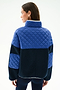 A woman with straight brown hair models the SPLITS59 Skylar Sherpa Jacket - Indigo/Cobalt from the back, featuring blue quilted fabric and black panels, against a white background.