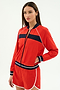 A woman wears the SPLITS59 Carrie Woven Nylon Jacket in Lotus Red/Indigo, paired with matching red shorts, standing against a plain white background.