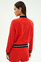 A woman with straight brown hair stands with her back to the camera, wearing the SPLITS59 Carrie Woven Nylon Jacket in Lotus Red/Indigo.