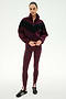 A woman stands facing forward against a plain white background, wearing the SPLITS59 Lottie Chevron Sherpa Full Zip Jacket in Dark Cherry/Black, paired with maroon stirrup leggings and black sneakers.