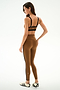 Model wears SPLITS59 Clare High Waist Rigor 7/8 - Toffee/Black set, standing sideways in white sneakers against a plain white background, looking down.