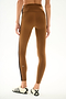 Model wears SPLITS59 Clare High Waist Rigor 7/8 - Toffee/Black, styled with white sneakers, shown from the back against a plain background.