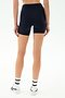 Seen from behind against a light background, a person wears SPLITS59 Airweight High Waist Short in Indigo, a seamless tank workout top, white socks, and white sneakers.