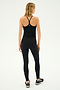 A person is seen from behind wearing the SPLITS59 Airweight Tank in black athletic wear, standing against a plain background in sneakers.