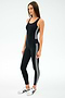Wearing the SPLITS59 Ella High Waist Airweight 7/8 leggings in Black/White with white sneakers, a person stands against a plain white background—ideal for hot yoga or your next workout.