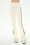 Wearing the SPLITS59 Raquel High Waist Supplex Flare pants in Creme/Black—featuring a cream color, high waist, black side stripes, and 4-way stretch Supplex fabric ideal for workouts—and white sneakers with black accents, this person stands against a plain light background.