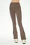 A person wearing the SPLITS59 Raquel High Waist Supplex Flare pants in Lentil/Black—a taupe, high-waisted flared style featuring black side stripes—paired with white sneakers, stands against a plain light background.
