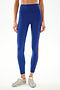 A woman wears SPLITS59 Clare High Waist Rigor 7/8 - Cobalt/Terracotta leggings with light gray sneakers, standing against a plain white background.