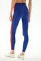 Model wears SPLITS59 Clare High Waist Rigor 7/8 - Cobalt/Terracotta leggings with a red side stripe and white athletic shoes, standing on a white background.
