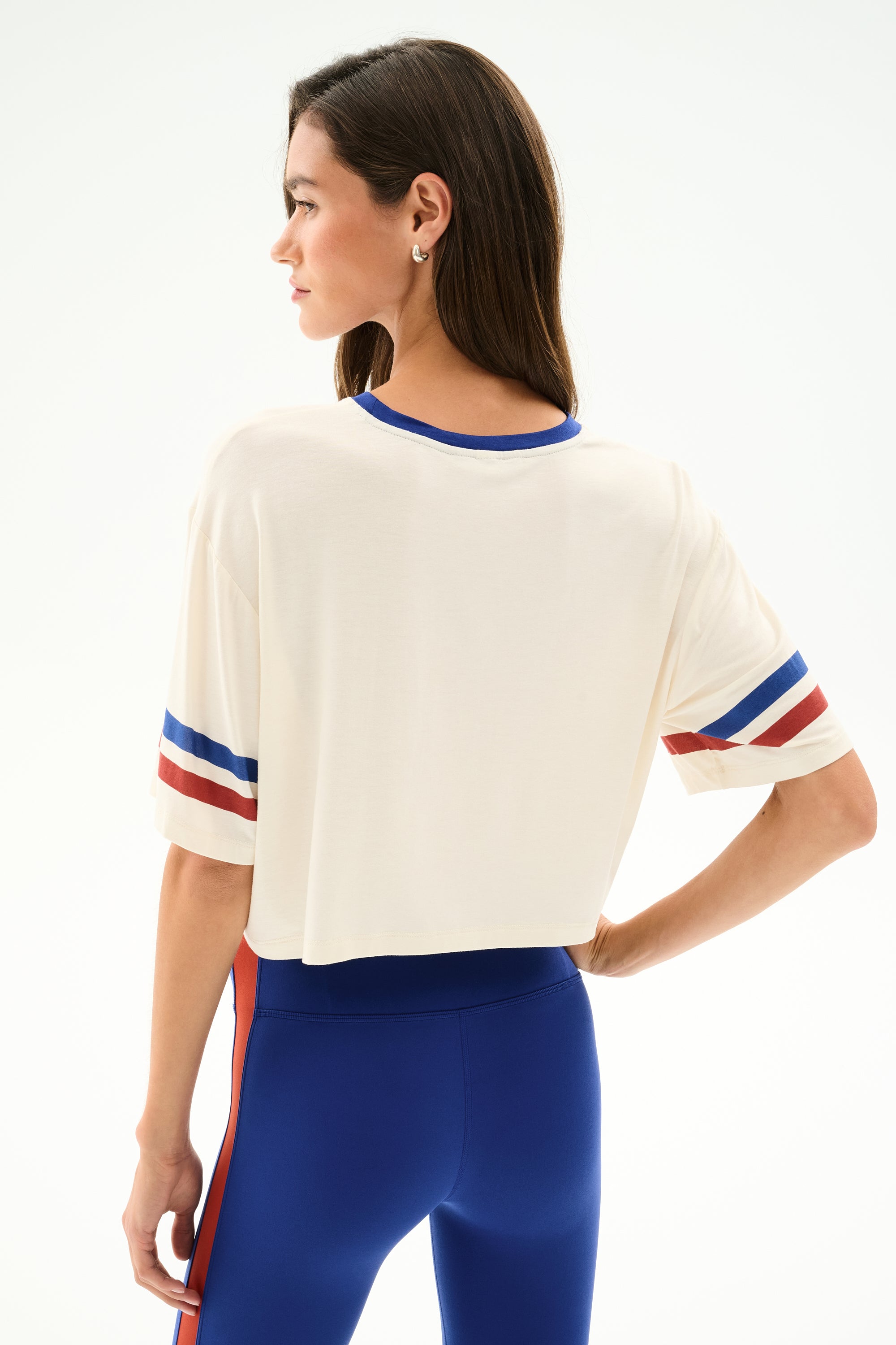 Woman wearing the Djuna Oversized Crop Jersey Tee - Creme/Cobalt by SPLITS59, shown from the back against a plain background.