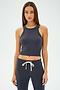 A woman with long hair, wearing a SPLITS59 Kiki Rib Crop Tank in graphite and matching jogger pants, stands against a plain background.