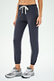 A person wears SPLITS59's Sonja Fleece Sweatpant in Graphite, featuring ultra-luxe fleece and a white drawstring, paired with gray sneakers—ideal for cool weather workouts—set against a plain background.