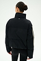 A woman with dark hair in a bun is photographed from behind against a plain white background, wearing the SPLITS59 Maeve Puffer Jacket in Black/Creme—crafted from 100% nylon—and black leggings.