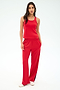 A woman faces forward in a SPLITS59 Mel Airweight Lite Tank in Pirate Red, paired with matching red pants with side stripes and white sneakers, set against a plain light backdrop.